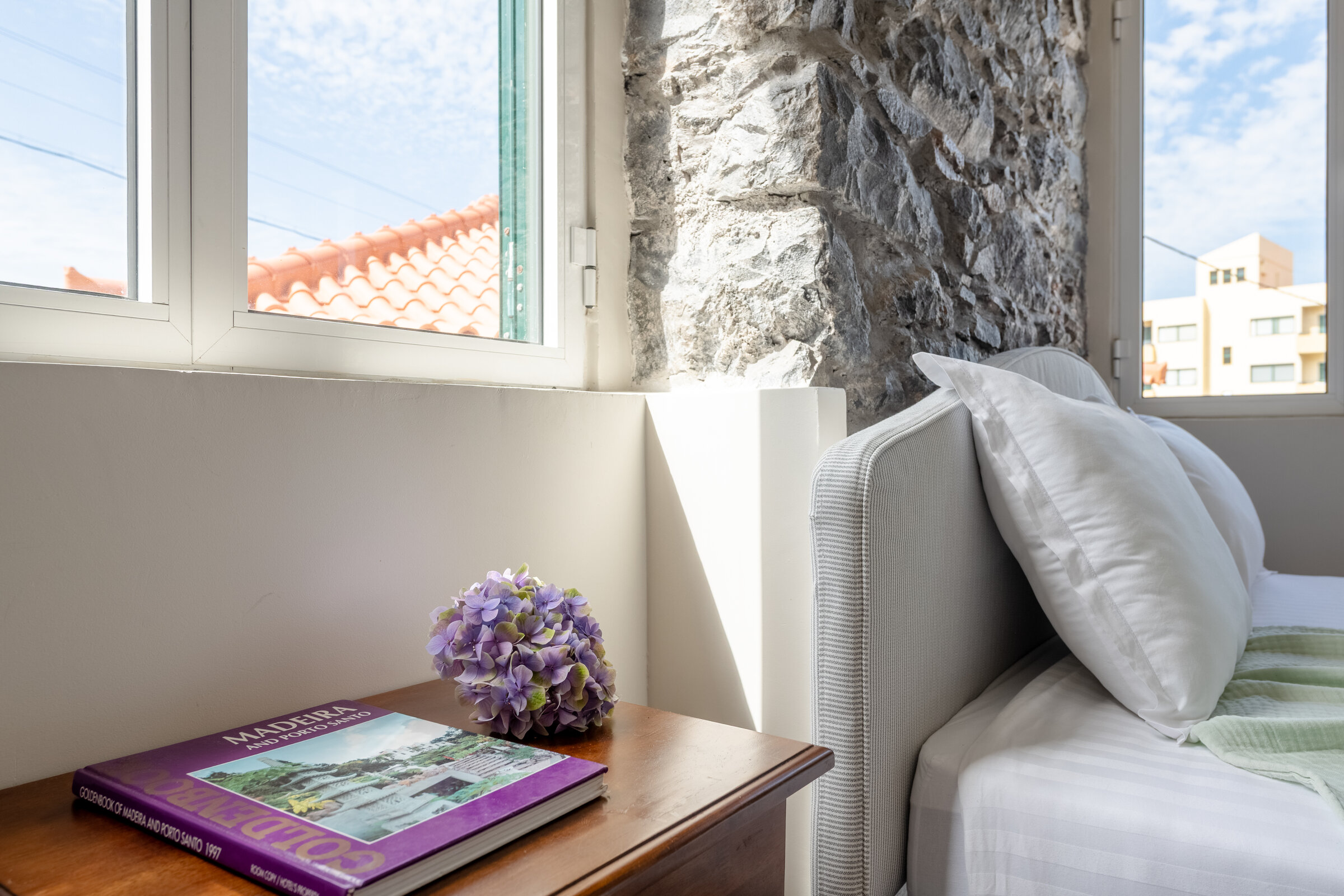 Cosy window nook with cushions and a book, natural light