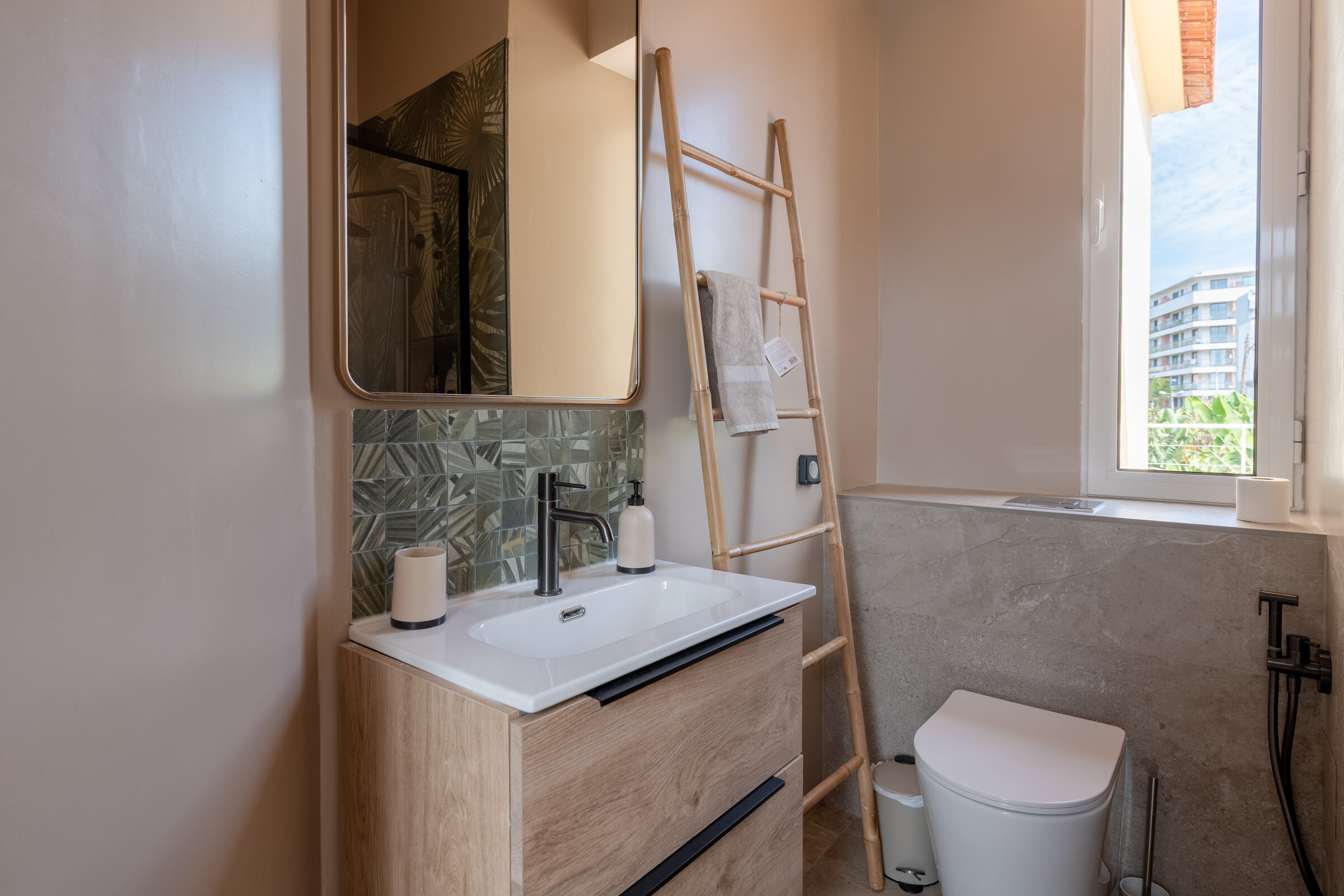 Bathroom vanity with mirror, ladder towel rail and window