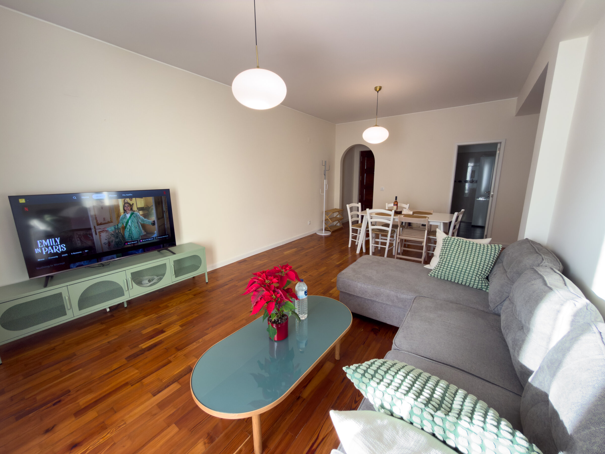Living room with sofa, TV and dining table, wood flooring