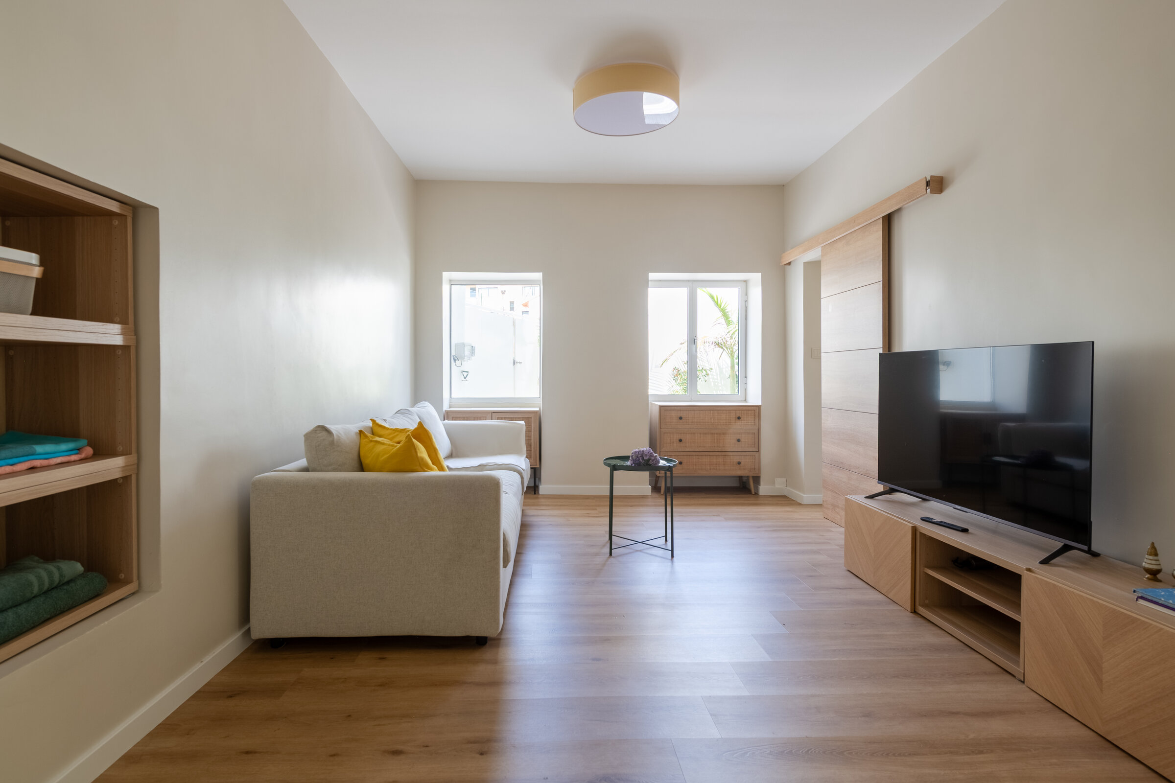First living room with sofa, TV and wood flooring