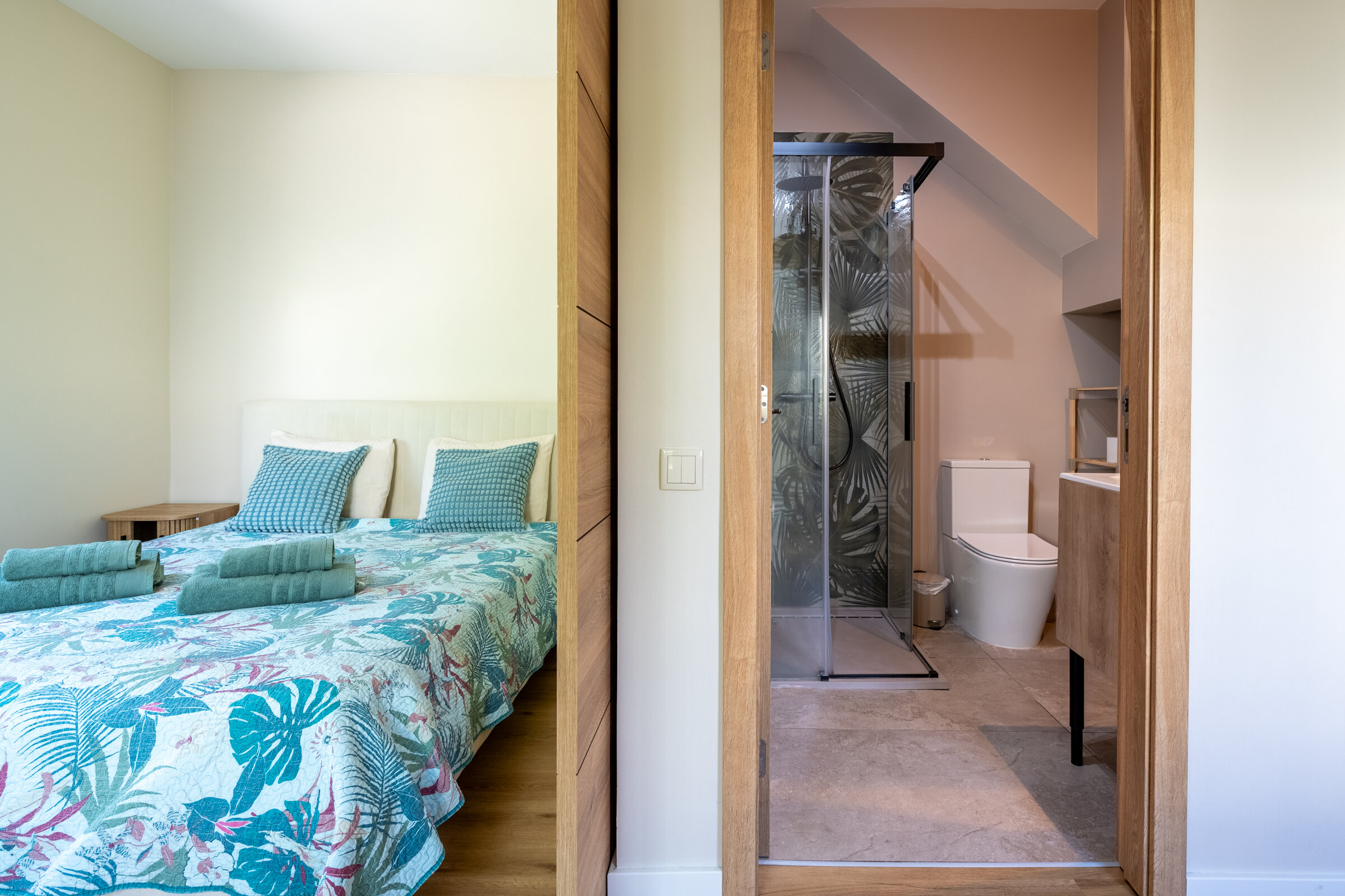 Bedroom with en-suite shower visible through the glass door