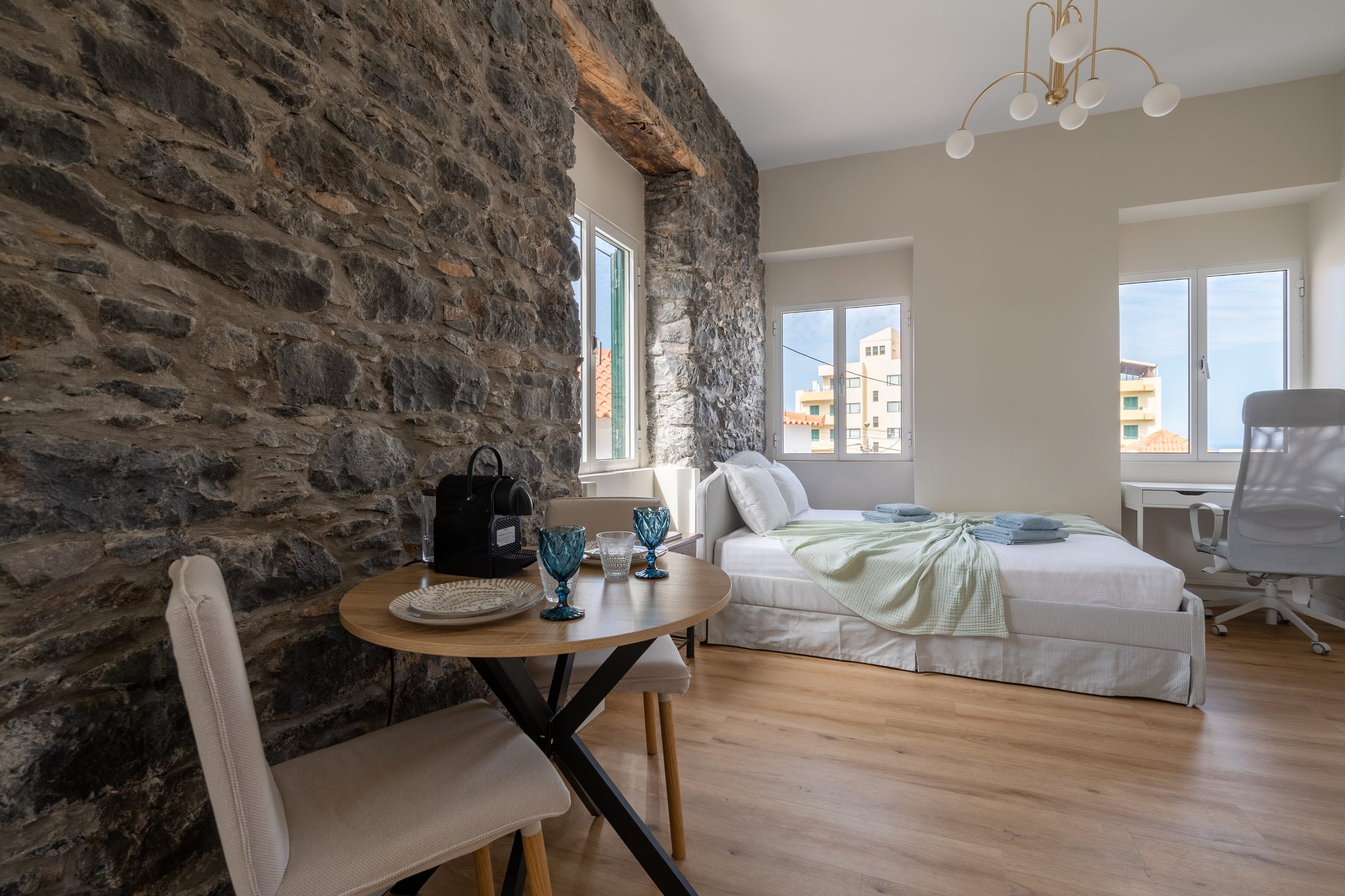 Bedroom with exposed stone wall and city view
