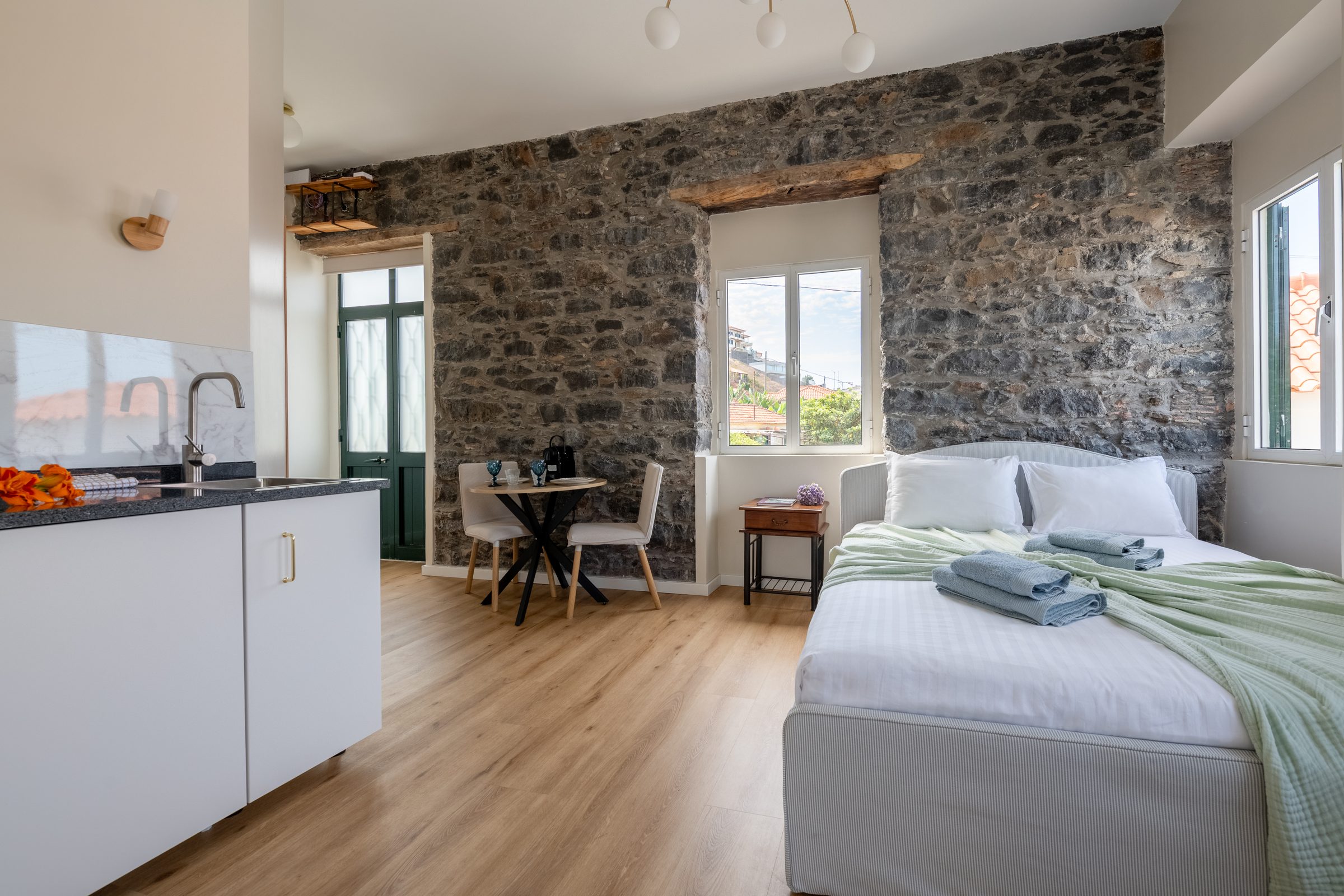 Bedroom with kitchenette and stone accent wall