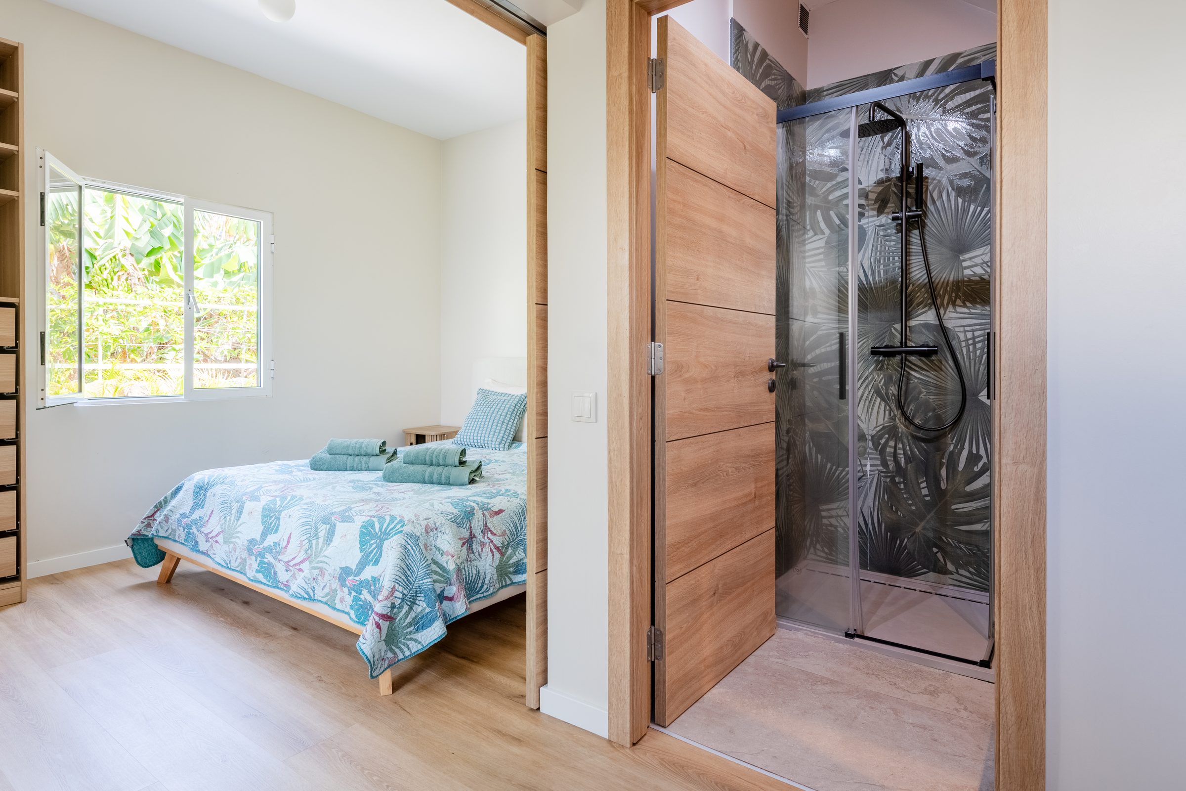 Bedroom with en-suite shower behind sliding doors